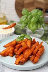 Sweet potato fries and basil on table, closeup