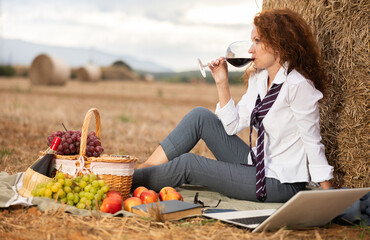Type representation of freelancer girl. Woman in blouse and suit is sitting next to haystack in...