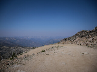 Switchback on shelfy dirt road in Sawtooth Mountains near Stanley Idaho with high up view of horizon