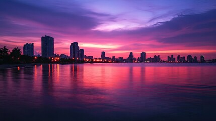 Naklejka premium City Skyline Silhouette Reflected in Calm Pink Water at Sunset
