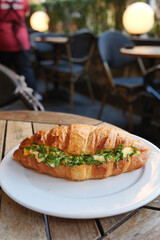 Enjoy a delicious croissant sandwich with fresh herbs and premium ingredients for an elevated taste