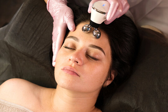 A client enjoys a relaxing microcurrent forehead massage as part of a facial treatment.