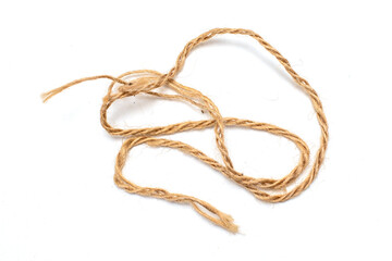 A long, thin, brown string is laying on a white background