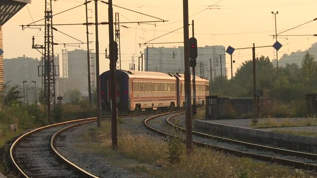 The train departs the bustling station. Wheels clatter on tracks, leaving behind familiar sights.
