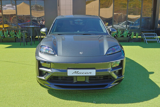 Porsche macan parked on green grass in front of building