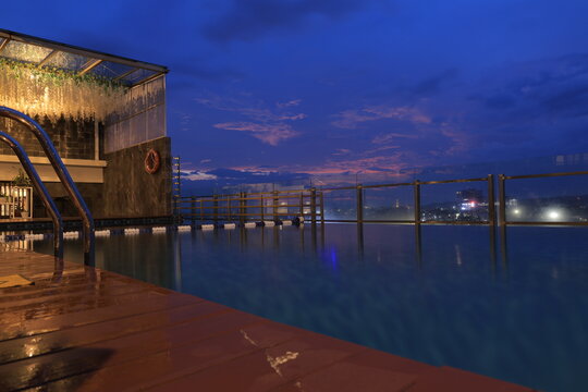 Skylounge infinity pool on rooftop with beutiful cityscape night view.