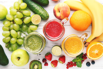 Fresh smoothies in glass jars with fruits and vegetables on wooden background