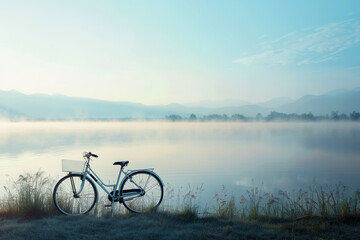 A bicycle is parked by a lake, with the water reflecting the sky