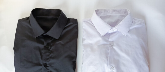 Black and white shirts on white background. Folded shirts. Washing and ironing men's shirts. Comparison. Laundry service advertising background. Shirt collars.