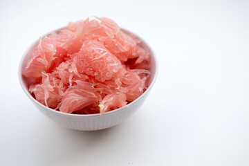 Fototapeta premium peeled red and pink pomelo in bowl on white background
