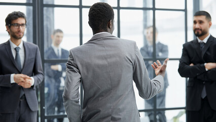 presentation with his colleagues during a meeting in an office boardroom