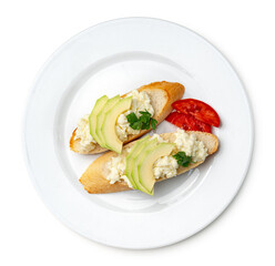 Fresh avocado and cheese spread on toasted bread garnished with cilantro and tomato