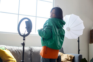 Young Asian Woman Blogger Showing Jumper While Recording Video For Social Networks At Home