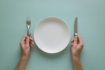 Top down minimalist table setting, hand holds plate, clean turquoise background
