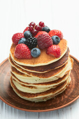 Stack of homemade american pancakes with berries . Top view