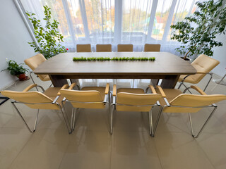 A long wooden table with a green plant in the middle