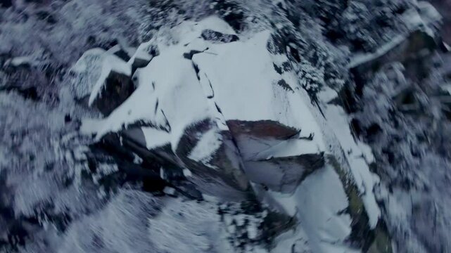 FPV drone captures close-up views of a rugged, snow-draped rock face at Mont Pinacle