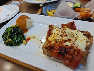 A juicy pork steak wrapped in bacon and topped with melted cheese, served with mashed potatoes and grilled vegetables. Perfect for food blogs, cookbooks, and restaurant menus.