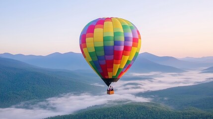 Fototapeta premium Colorful hot air balloon over misty mountain valley, early morning light, scenic flight, calm and peaceful adventure