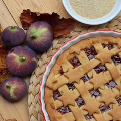 Top view of Tart with dark fig jam in a white ceramic cake pan on wooden table 