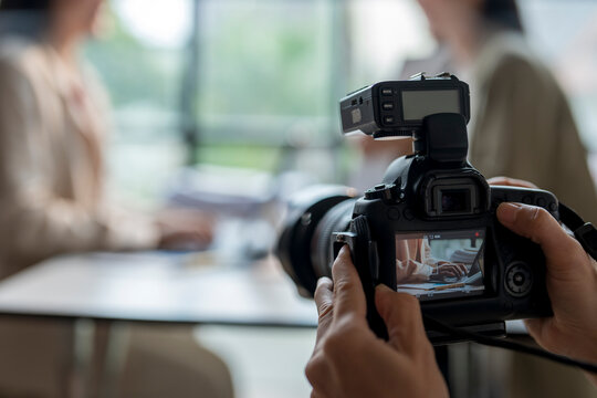 Photographer taking photo of businesswomen working on project