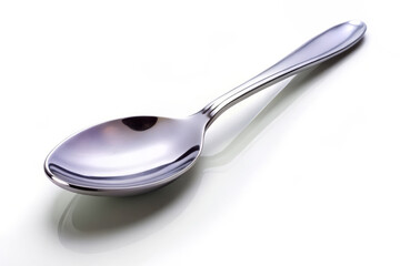 shiny silver spoon rests diagonally on pure white background, showcasing its sleek design and reflective surface. This captures elegance and simplicity of spoon