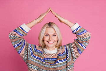 Portrait of pretty aged woman arms roof above head wear sweater isolated on pink color background