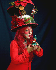 Woman in fantasy Christmas makeup holding a plush elf in her hands.