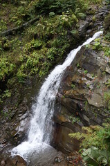 A beautiful waterfall in a mountainous and wooded area. Mendelikha Park.