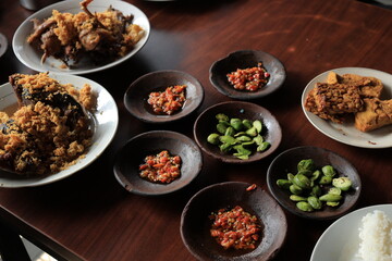 Lalapan or fresh raw vegetables basket with Pete (petai), chili sauce or sambal