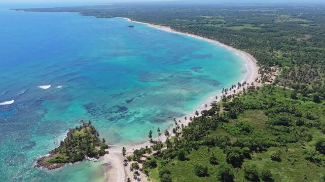 Turquoise clear water of Caribbean Sea with coral reef along Coquitos Beach, Dominican Republic. Aerial top down shot. Exotic and tropical island with picturesque landscape.