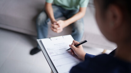 sad male sitting on sofa Patient discussing mental health issues with psychologist. depressed asian man mental health treatment