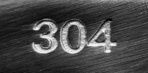 Scratched stainless steel numbers 304 or three hundred four on a piece metallic panel. Abstarct...