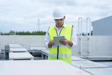 Asian maintenance engineer works on the roof of factory. contractor inspect compressor system and...
