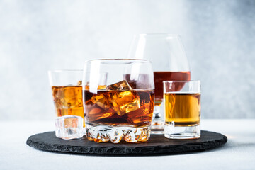 Strong alcohol drink set at light background. Cognac, whisky and rum.