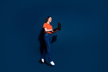 Photo of charming adorable woman wear trendy clothes hold netbook device isolated on dark blue color background