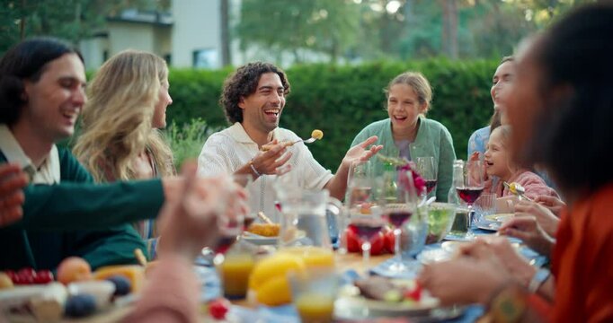 Parents, Children, Relatives and Friends Having an Open Air Barbecue Dinner in Their Backyard. Old and Young People Talk, Chat, Have Fun, Eat and Drink. Garden Party Celebrations on a Warm Day