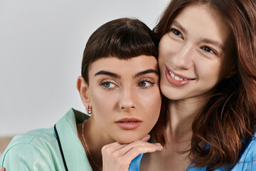 Two women in pajamas share a tender moment, their faces close together, radiating love and contentment.