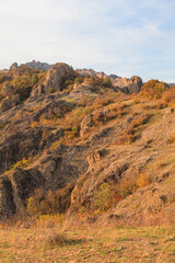 a panoramic view of autumn landscape with mountain hills surrounded by trees with yellow and red foliage at birtvisi canyon in georgia at a sunset light