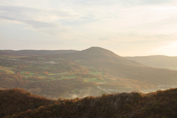 a panoramic view of autumn landscape with mountain hills surrounded by trees with yellow and red foliage at birtvisi canyon in georgia at a sunset light