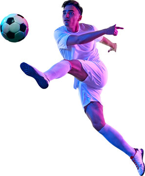 Focused football player, in vibrant neon light during training session, works on controlling ball in air against transparent background. Concept of championship, sport events, final game. Ad
