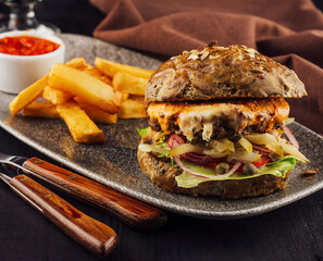 Delicious burger served with french fries and sauce on plate