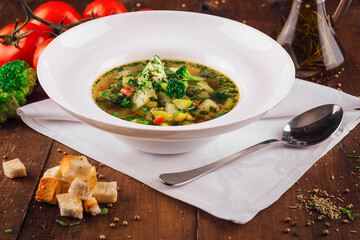 Delicious hot vegetable soup with broccoli and croutons on wooden table