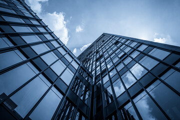 Fototapeta premium Dramatic Low-Angle View of Contemporary Skyscraper Against Cloudy Sky