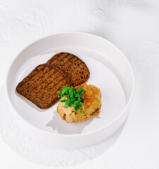 Chicken liver pate with mango puree and rye bread on white plate