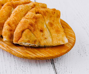 Traditional balkan pies with cheese filling resting on wooden plate