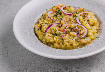 Baba ghanoush with red onions and herbs on a plate