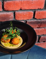 Gourmet fried balls on elegant black plate