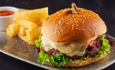 Delicious burger with beef, tomato, cheese and salad served on plate
