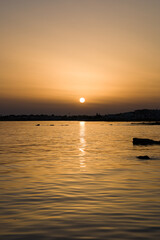Tramonto a Marina di Ragusa con la costa e il faro di Puntasecca sullo sfondo